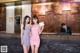 A couple of women standing next to each other in front of a reception desk.