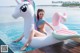 A woman in a bikini sitting on an inflatable unicorn float.