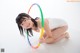 A young woman is playing with a hula hoop.