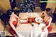 Two women sitting at a table with a christmas tree in the background.